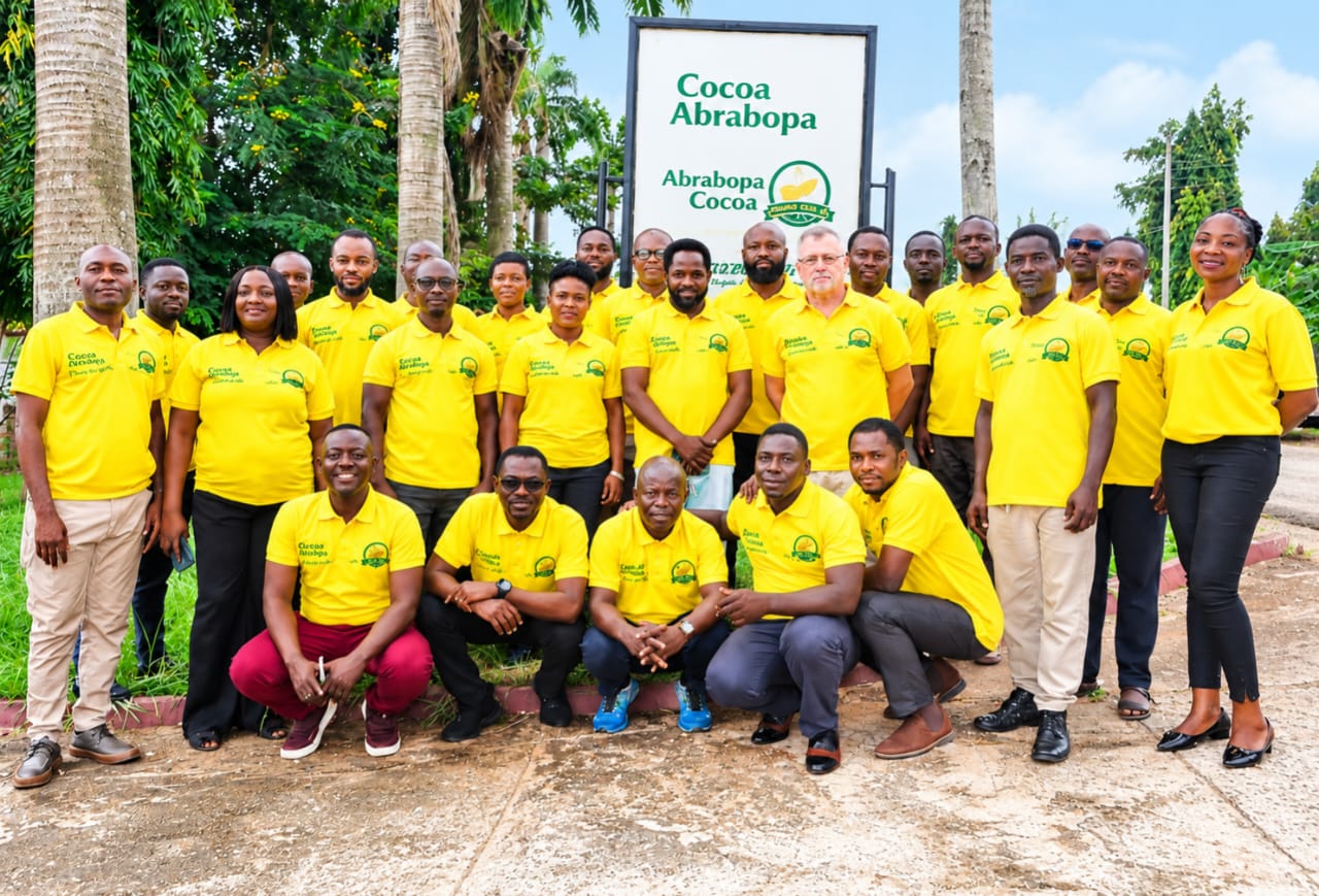 Abrabopa colleagues in yellow shirts gathered outside beside the company sign